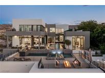 Stunning modern home featuring a multi-level pool, spa, outdoor kitchen, and lounge areas with beautiful mountain views at 1491 Reims Dr, Henderson, NV 89012
