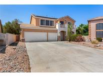 Two-story stucco home showcasing a two-car garage, desert landscaping, and a balcony at 1798 Lakewood Dr, Henderson, NV 89012