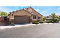 Inviting single-story home featuring a two-car garage, stone accents and well-manicured landscaping at 4508 Dragon Fly Creek Ave, North Las Vegas, NV 89031