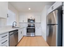 Modern kitchen featuring stainless steel appliances, white cabinetry, and light countertops at 50 Armstrong Cir, Henderson, NV 89015