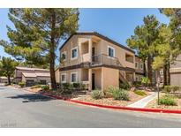 Condo exterior showing the front facade, mature landscaping, and a balcony with stairs at 5250 S Rainbow Blvd # 2101, Las Vegas, NV 89118