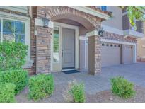 Charming front entrance features a stone archway and well-maintained landscaping, plus three-car garage at 9628 Matanzas Creek Ct, Las Vegas, NV 89139