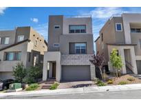 Contemporary home with gray stucco and stone accents plus desert landscaping at 11695 Gentle Birdsong Ave, Las Vegas, NV 89138