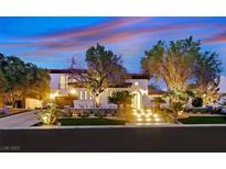 Elegant two-story home featuring a beautifully landscaped yard, illuminated stairs, and a warm, inviting ambiance at 11906 Port Labelle Dr, Las Vegas, NV 89141