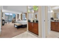 Bright bedroom featuring a luxurious bed, workspace and a convenient wet bar area at 135 E Harmon Ave # 407, Las Vegas, NV 89109