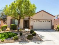Inviting single-story home featuring a well-manicured lawn, desert landscaping, and an attached two-car garage at 2473 Luminous Stars St, Henderson, NV 89044