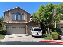 Two-story home with a tan stucco finish, tile roof, three-car garage and a well-manicured front lawn at 259 Rockwell Springs Ct, Henderson, NV 89012