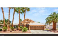 Charming single-story home with mature palm trees, a tile roof, and a three-car garage at 286 Bowsprit Ct, Las Vegas, NV 89183