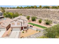 Two-story home featuring a two-car garage and a beautifully xeriscaped front yard with artificial turf at 3169 Crystal Moon Rd, Henderson, NV 89052