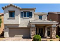 Charming two-story home featuring a stone-accented entrance, a well-kept lawn, and a two-car garage at 1034 Fish Pond Ave, Henderson, NV 89014