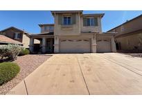 Two-story home featuring a large driveway, three-car garage and neutral toned stucco exterior at 1177 Twinkling Meadows Dr, Henderson, NV 89012