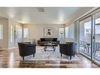 Bright living room features modern furnishings, wood floors, and a sliding glass door to the outdoor patio at 3125 N Buffalo Dr # 1133, Las Vegas, NV 89128