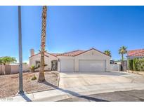 Single-story home featuring an attached two-car garage, desert landscaping, and a red-tiled roof at 4010 Hemphill St, North Las Vegas, NV 89032