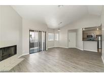 Bright living room with fireplace, wood floors, and sliding door to the outside at 5038 S Rainbow Blvd # 206, Las Vegas, NV 89118