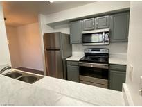 Well-lit kitchen featuring stainless steel appliances, gray cabinets, and white countertops at 555 E Silverado Ranch Blvd # 2030, Las Vegas, NV 89183