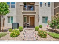 Charming townhome with a small front yard featuring decorative landscaping and a second-story balcony at 668 Tiarella Ln, Henderson, NV 89015