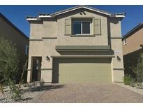 Two-story home featuring a neutral-toned facade, a two-car garage, and a well-maintained, stylish brick driveway at 10434 Luna Mezzo St Ave # Lot 188, Las Vegas, NV 89141