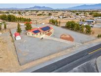 Expansive single-story home features a circular driveway, solar panels, desert landscaping, and mountain views at 1800 Red Rock Dr, Pahrump, NV 89048