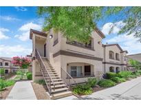 Exterior view of a condo featuring a staircase and landscaped yard under a sunny sky at 2291 W Horizon Ridge Pkwy # 6131, Henderson, NV 89052