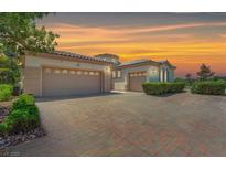 Spacious multi-car garage with a brick paved driveway and manicured landscaping at 2997 Via Meridiana, Henderson, NV 89052