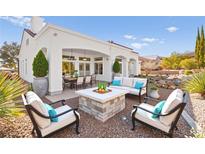 This backyard patio features a stone fire pit, comfortable seating, and a covered outdoor dining area at 10920 Grand Haven Ave, Las Vegas, NV 89134