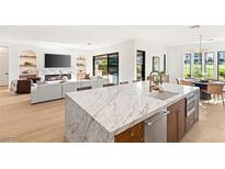 Open-concept kitchen featuring a marble island, stainless steel appliances, and seamless flow into the living area at 1987 Orchard Mist St, Las Vegas, NV 89135