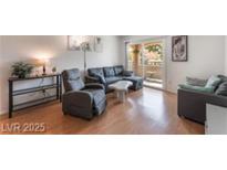 Bright living room featuring modern furnishings and a sliding glass door to the balcony at 221 Mission Catalina Ln # 104, Las Vegas, NV 89107