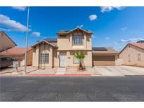 Two-story home featuring a neutral stucco exterior, two-car garage, and a small palm tree in the front yard at 2745 Poppyseed Way, Las Vegas, NV 89142