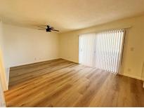 Bright room featuring wood-look floors, a ceiling fan, and sliding glass doors leading to outdoor space at 3270 Liahona Way, Las Vegas, NV 89121