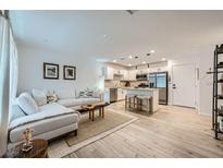 Bright living room flows into the kitchen featuring an island with stool seating and stainless steel appliances at 709 Pickled Pepper Pl, Henderson, NV 89011