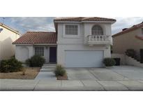 Charming two-story home with a terracotta roof, a balcony, a two-car garage, and a well-maintained front yard at 8704 Autumn Wreath Ave, Las Vegas, NV 89129