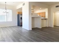 Bright living room featuring modern gray wood-look floors and an open floor plan to the kitchen at 23 E Agate Ave # 308, Las Vegas, NV 89123