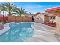 Inviting backyard pool features a waterfall, lounge chairs, and privacy fence perfect for relaxation at 5005 Harmony Ave, Las Vegas, NV 89107