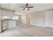 Open-concept living room boasts a ceiling fan and wood-look flooring, providing a bright and airy feel at 7300 Pirates Cove Rd # 1032, Las Vegas, NV 89145