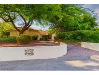 Landscaped front yard with mature trees provides shade and curb appeal to this charming property at 8120 W Red Coach Ave, Las Vegas, NV 89129