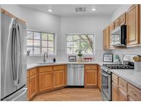Bright kitchen features stainless steel appliances, granite countertops and wood flooring at 9047 Harbor Wind Ave, Las Vegas, NV 89178