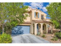 Charming two-story home with desert landscaping, blue shutters, and a matching garage door at 10428 Mulvaney Cir, Las Vegas, NV 89141