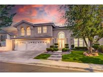 Stunning two-story home with a three-car garage, lush landscaping, and inviting entrance at 2496 Ram Crossing Way, Henderson, NV 89074