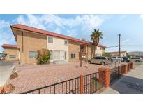 Two-story tan building with a red tile roof, desert landscaping, black fencing and ample parking at 2915 Cedar Ave # 11C, Las Vegas, NV 89101