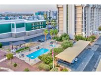 Aerial view of the community pool, parking and palm trees surrounded by buildings in the background at 3930 University Center Dr # 412, Las Vegas, NV 89119