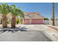 Two-story home with a two-car garage, palm trees, and desert landscaping for an appealing curb presence at 5907 Zawawi Ct, Las Vegas, NV 89110