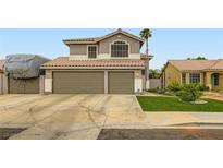 Charming two-story home featuring a spacious three-car garage and well-manicured front lawn at 1325 Baychester Dr, Henderson, NV 89002