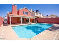 A refreshing pool provides a welcome escape in the backyard of this inviting coral-colored home at 1428 Daybreak Dr, Las Vegas, NV 89108