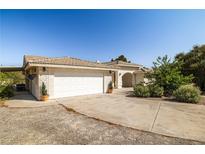 Charming single-story home featuring a wide driveway, two-car garage, and well-maintained front yard at 170 Dove St, Pahrump, NV 89060