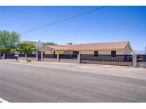 Charming single-story home featuring desert landscaping, a secure fence, and a tile roof at 2935 Hardin Dr, Henderson, NV 89074