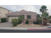 Charming single-story home with desert landscaping, tile roof, and a paved driveway leading to the garage at 449 Orchid Oasis Ave, North Las Vegas, NV 89031