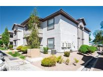 A well-maintained two-story condo featuring neutral stucco and brown trim, set amongst desert landscaping at 45 Maleena Mesa St # 223, Henderson, NV 89074