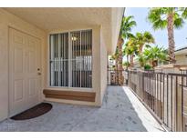 Welcoming front entrance with door, security screen, and palm trees lining the walkway in a well-maintained community at 7155 S Durango Dr # 303, Las Vegas, NV 89113