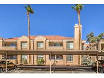Attractive condo building with terracotta tile roof, beige facade, balconies, and shaded parking area at , Las Vegas, NV 89119