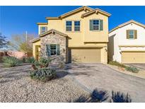 Two-story home featuring a stone facade, tan exterior, and a two-car garage with a brick paved driveway at 8992 Sparkling River Ct, Las Vegas, NV 89178